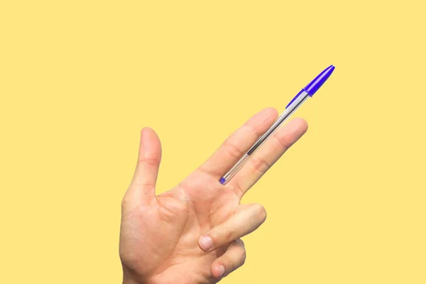 Concept of freedom of speech and information, stop censorship. Hand holding an open pen like a gun. Defend the freedom of Journalism. Yellow background