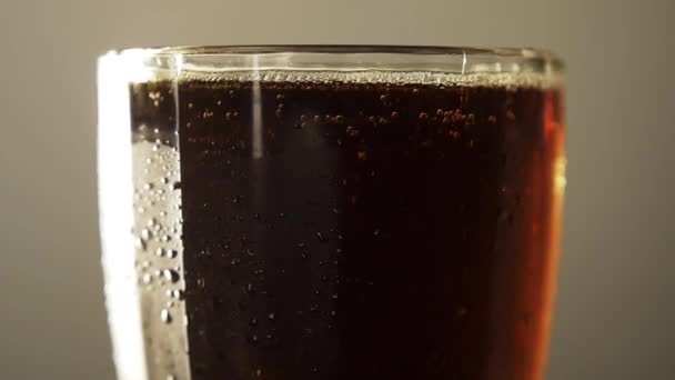 Γυάλινο πλήρες σκούρο σκάφος μπύρα closeup περιστρέφεται με σταγόνα συμπυκνώματος κρύο ποτό — Αρχείο Βίντεο