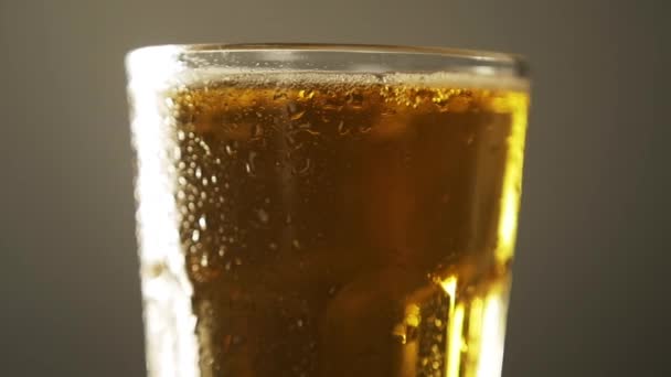 Cerveza artesanal de vidrio llena de luz de cerca girar con gota de condensación bebida fría — Vídeo de stock