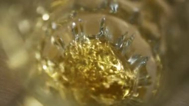 Sarı hünerli bira boş bir bardağa dökülür. Yakın plan ve köpüren yavaş çekim.