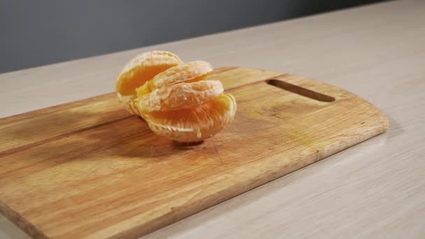 Soyulmuş portakal dilimleri mutfak masasına yavaşça düşer, çok güzel görünür. — Stok video