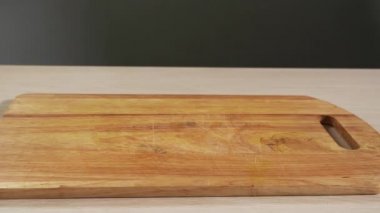 Soyulmuş elma dilimleri mutfak masasına yavaşça düşer, yakın plan görüntülenir.