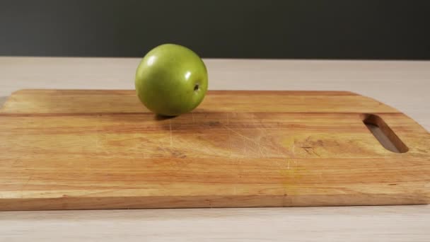 Cae en cámara lenta fruta de manzana verde en la mesa de cocción y rebotando de cerca — Vídeo de stock