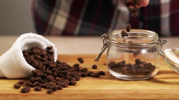 La gente getta arrosto chicco di caffè in vaso rallentamento primo piano, riempire contenitore arabica — Video Stock