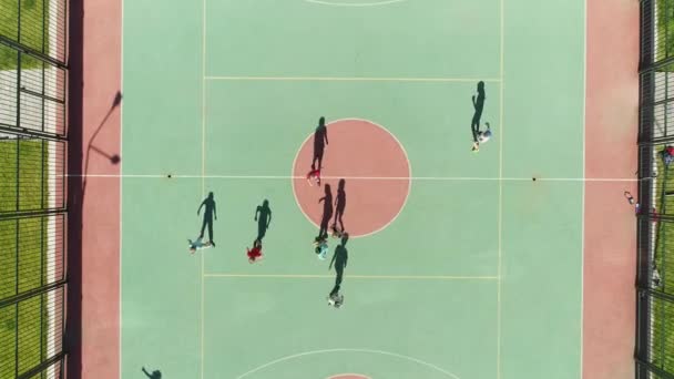Przesuń drone cień dzieci grać w piłkę nożną zielony stadion słoneczny dzień z 4k. — Wideo stockowe