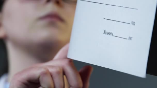 Жіночий документ обертання папки рук крупним планом. Дівчина дивиться каталог повільний рух . — стокове відео