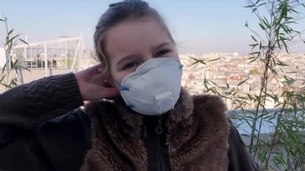 Möt sjuk liten flicka i mask titta på kameran närbild. Infektion koronavirus 4K. — Stockvideo