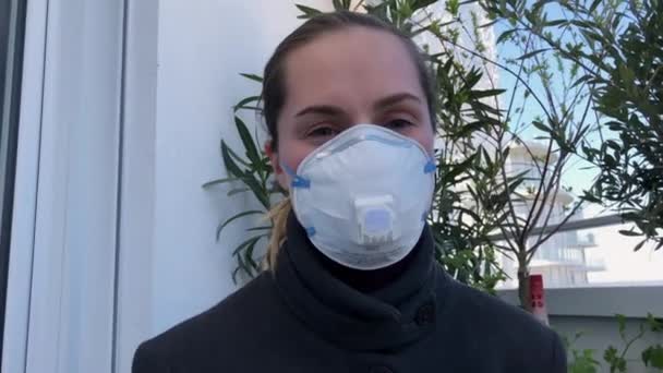 마스크를 쓴 얼굴 소녀가 카메라를 가까이 서 보고 있습니다. 유행성 전염병 코로나 바이러스 4K — 비디오