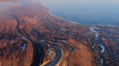 Dağ manzaralı İHA 'da seyyar araç kavisli yol. Okyanus kıyısında bir kargo kamyonu.