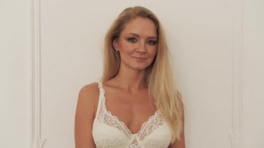 Seksi portre, gülümseyen kız iç çamaşırları yakın çekim. Sutyenli seksi sarışın, 4K kamerasına bak..