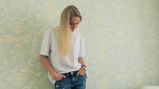 Muchacha atractiva de pie en camiseta blanca de cerca. Caliente rubia stand casa ropa — Vídeos de Stock