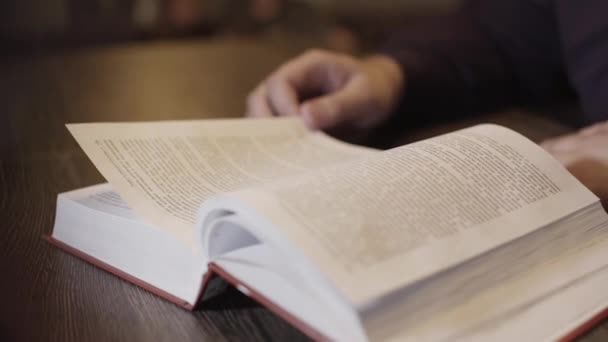 Homem lendo livro mão vira através de página romance closeup. braço masculino livro estudante 4K — Vídeo de Stock