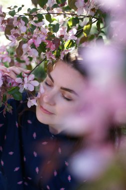 Kadının yanına yeni gelişen ağaç bahar