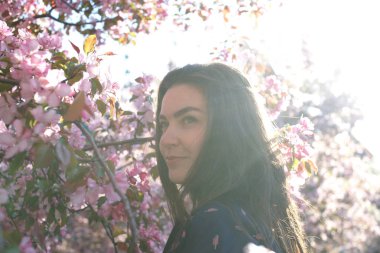 Kadının yanına yeni gelişen ağaç bahar