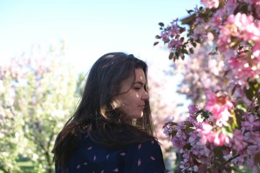 Kadının yanına yeni gelişen ağaç bahar