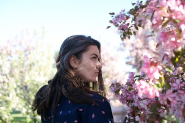 Kadının yanına yeni gelişen ağaç bahar