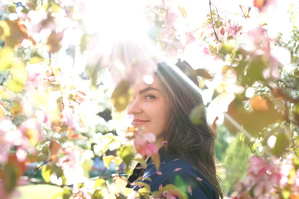 Vrouw in de buurt van bloeiende boom in het voorjaar — Stockfoto