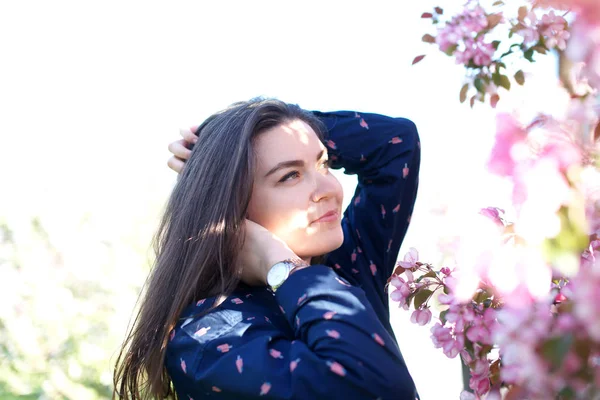 Frau in der Nähe blühender Bäume im Frühling — Stockfoto