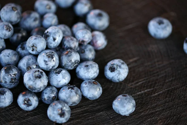 Blaubeeren auf dunklem Holzgrund — Stockfoto