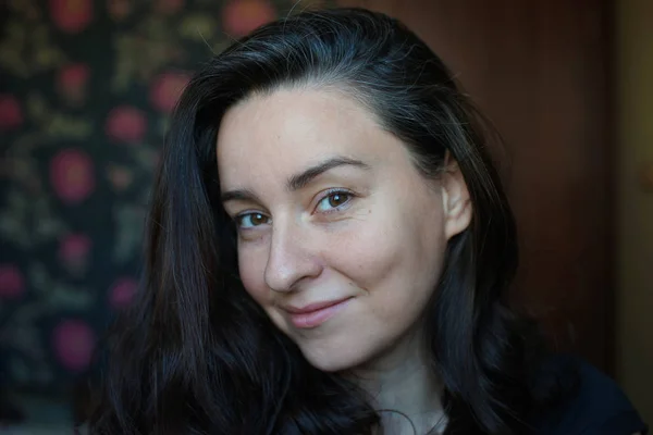 Portrait of a woman without makeup with a little gray hair