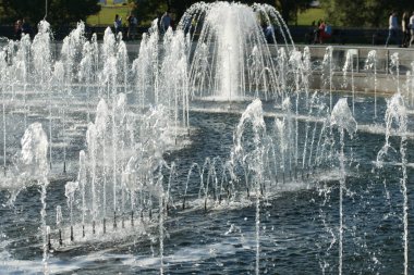 Şehir çeşmesinden köpük fışkıran su damlaları.