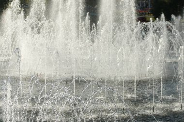 close up of flow splashes of water of city fountain with foam jets of water