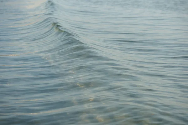 青い水の背景を持つ海岸沿いの小さな波が — ストック写真