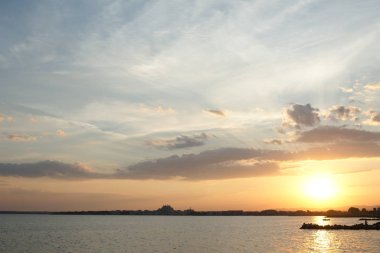 Mavi gökyüzü ve denizin karşısında turuncu ve beyaz bulutların basit renkleri güzel gökyüzü dramatik günbatımı ve gündoğumu gökyüzü.