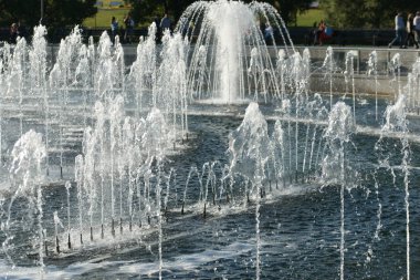 Şehir çeşmesinden köpük fışkıran su damlaları.