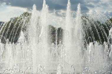 close up of flow splashes of water of city fountain with foam jets of water