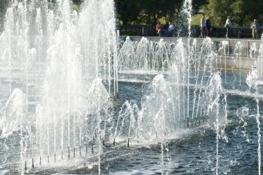 Şehir çeşmesinden köpük fışkıran su damlaları.