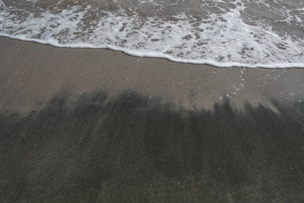 海水の波を背景に砂のビーチ — ストック写真