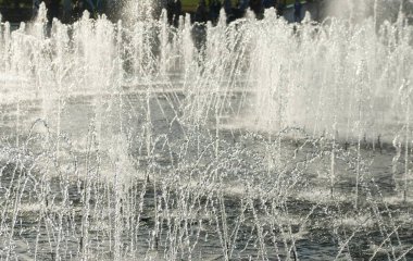 close up of flow splashes of water of city fountain with foam jets of water