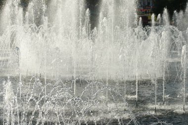 close up of flow splashes of water of city fountain with foam jets of water