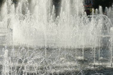 close up of flow splashes of water of city fountain with foam jets of water