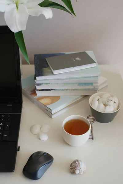 Стеклянная Ваза Белыми Цветами Лилии Чашкой Чая Ноутбуком Книгами Белом — стоковое фото