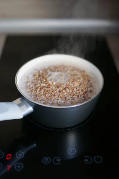 Boiling Buckwheat Saucepan Electric Black Stove Glossy Surface — Stock Photo, Image
