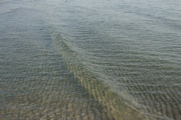 海水の背景がはっきりしている海岸沿いの小さな波は — ストック写真