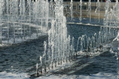 close up of flow splashes of water of city fountain with foam jets of water