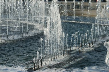 close up of flow splashes of water of city fountain with foam jets of water