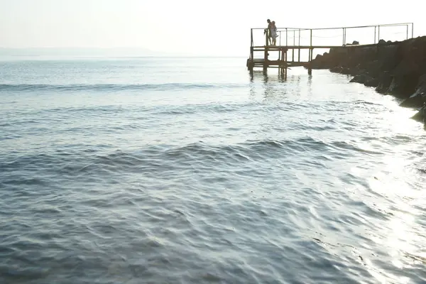 Denizin Arka Planında Tahta Merdivenlerde Duran Bir Çift Insan — Stok fotoğraf