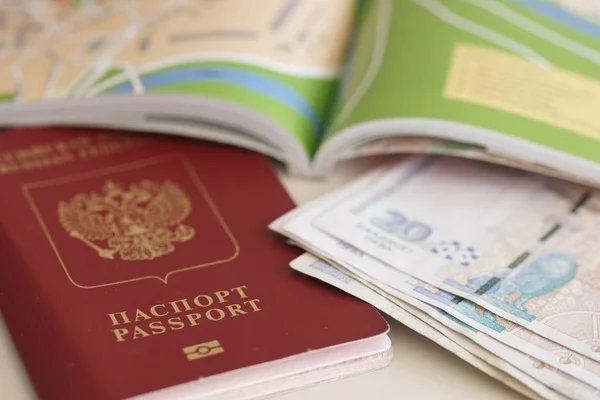 Russian passport with foreign currency money and world map on table background