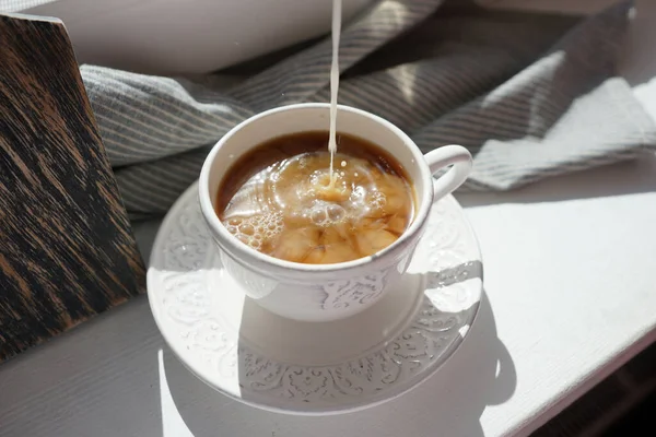 Süt damlası sade kahveye dökülür.