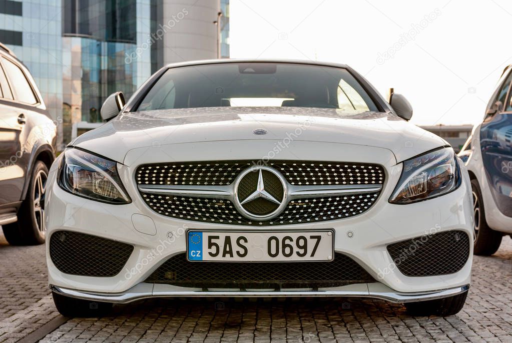 PRAGUE, THE CZECH REP., NOVEMBER 27, 2016: Closeup of front view Luxury car white cabrio Mercedes-Benz C200 with red roof. Car parking in front of car store Daimler