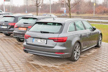 Audi araba satıcısı Audi önünde park etmiş.