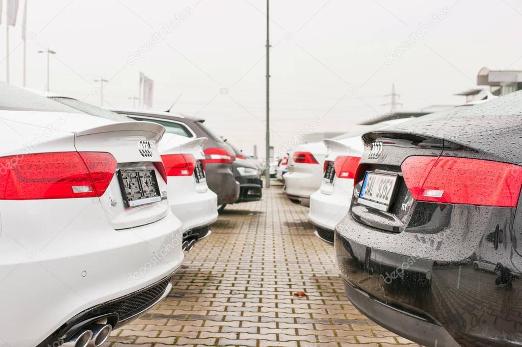 PRAGUE, THE CZECH REPUBLIC, 18.12.2016 - Audi cars parked in row in front of official car dealer Audi in Prague. Rear view of parked white and black cars in row.