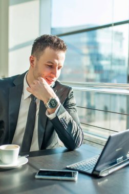 Genç işadamı ofisinde oturuyor.