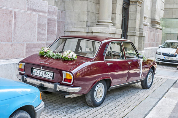 Крупный план свадебного автомобиля Peugeot 504 с цветами
