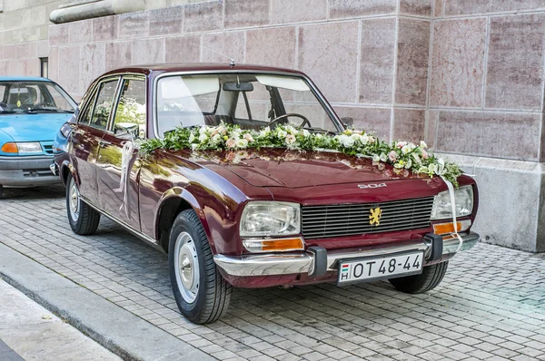 Closeup of wedding car Peugeot 504 with flowers — Stock Photo, Image