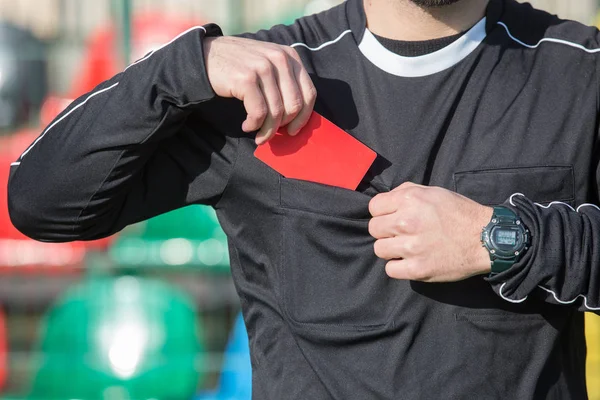 Kırmızı kart gösteren futbol hakemi.